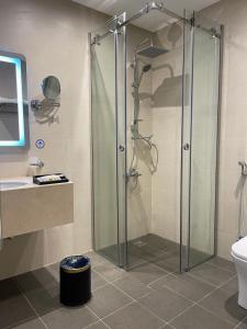 利雅德Hosta Hotel Suites的带淋浴、卫生间和盥洗盆的浴室