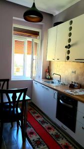 奥里库姆Louis Appartment的厨房配有白色橱柜、桌子和水槽。