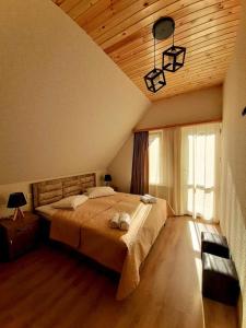 卡兹贝吉Kazbegi Inn的一间卧室设有一张大床和木制天花板