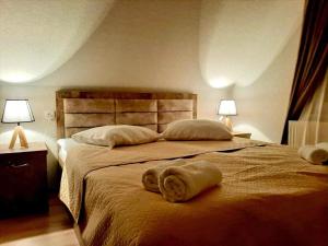 卡兹贝吉Kazbegi Inn的一间卧室配有一张大床和毛巾