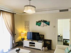 马拉加Apartamento a 50 metros de la playa malagueta con vistas al mar的客厅配有白色橱柜上的平面电视