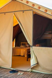波讷地区圣朱利安Tente Lodge La Téouleyre的客房内的帐篷,配有一张床