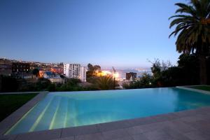 瓦尔帕莱索卡萨伊格拉斯酒店的游泳池,晚上可欣赏到城市景观