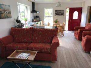 科克Lakeside Lookout Bantry的客厅配有红色的沙发和桌子
