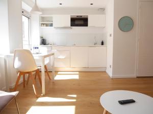 里尔查韦多特公寓的厨房配有白色橱柜和白色桌子
