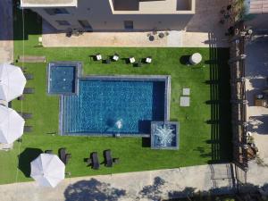 卡特罗斯Orion Eco Suites的享有游泳池和带遮阳伞的草坪的顶部景致