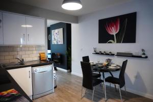 波塔当VIP Church Street Apartment的厨房以及带桌子、厨房和桌椅的用餐室。