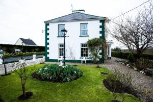 MilltownBruckless Rest - Fine Country Living的白色绿色的房子,设有花园