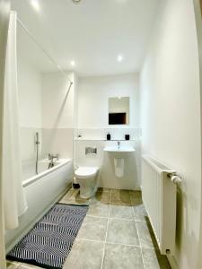 朴次茅斯2 Double beds OR 4 Singles, 2 Bathrooms, FREE PARKING, Smart TV's, Close to Gunwharf Quays, Beach & Historic Dockyard的白色的浴室设有水槽和卫生间。