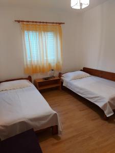 奥库格哥恩基Apartmani Tatjana的配有2张床的客房,设有窗户和木地板