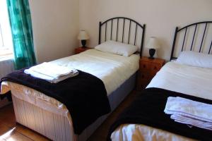 利默里克Sporting Lodge Shanagolden的一间卧室配有两张带衬衫的床
