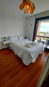 罗萨里奥1 dormitorio - zona Pichincha - Nuevo的卧室设有一张白色大床和一扇窗户。