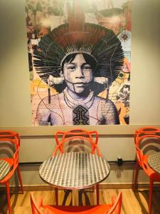 里贝朗普雷托Hotel Apiacas的一张桌子和椅子,上面有一幅女人的画