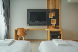 坤敬The Cotton Tree Hometel的一间酒店客房,设有两张床和电视