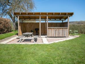 Nieder-EmmelsSpacious holiday home in the Ardennes with sauna的野餐棚,带野餐桌和烧烤架