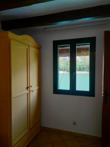 Sant Llorenç de MontgaiLo Raconet的客房设有窗户和橱柜。