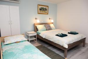 波尔托罗Guesthouse Emilia的一间卧室设有两张床和床头柜