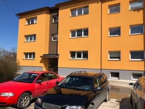 哈普萨卢Apelsini apartment的两辆汽车停在大楼前的停车场