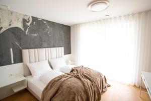 纳图尔诺Residenz Hofer的卧室设有白色的床和大窗户