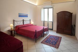 特拉帕尼Case Vacanze "Residenze Trapanesi"的一间卧室设有红色的床和窗户。