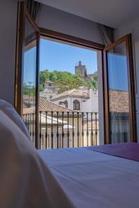 格拉纳达格拉纳达斯门精品酒店的一间卧室设有窗户,享有建筑的景色