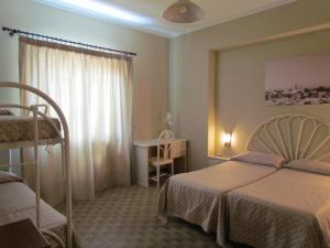 利帕里科拉罗酒店的一间卧室配有两张床、一张桌子和一张书桌
