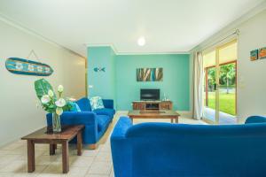 蒂蒂卡韦卡Island Time Villas的客厅配有蓝色的沙发和电视