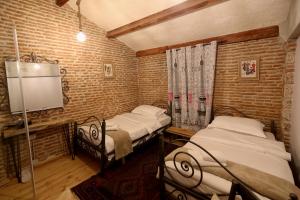 戈里察Le Petit Secret, Korce, Albania的砖墙客房中的两张单人床