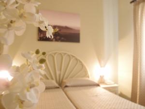 利帕里科拉罗酒店的一间卧室配有一张白色鲜花的床