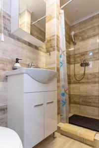 哈卡尼Lili Apartman的浴室配有白色水槽和淋浴。