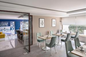 戛纳Juliana Hotel Cannes的一间带桌椅和钢琴的用餐室