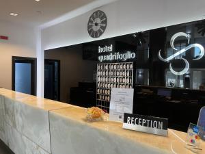 波米利亚诺达尔科HOTEL QUADRIFOGLIO的酒店的柜台,有标志