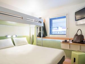 波尔多ibis budget Bordeaux Centre Mériadeck的酒店客房设有床和窗户。