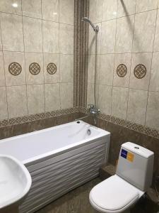 乌法Комфортная квартира на Комсомольской 148的浴室配有卫生间、浴缸和水槽。