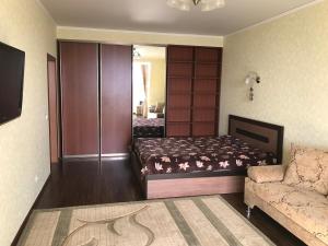 乌法Комфортная квартира на Комсомольской 148的一间带床和沙发的小卧室