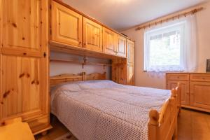 索拉加Residence Sas de le Undesc的一间卧室配有一张带木制橱柜的床和窗户。