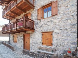 索拉加Casa Riccardo的带阳台和木门的石头建筑