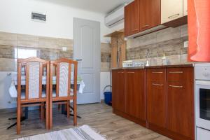 哈卡尼Lili Apartman的厨房配有木制橱柜和桌椅