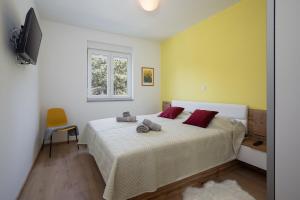 梅杜林Apartments Jan&Enzo的一间卧室配有一张带红色枕头的床和一扇窗户