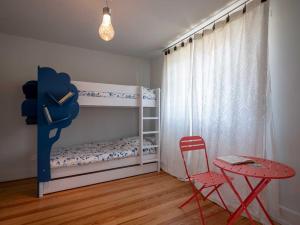 BoerschGîte Les Volets Bleus的一间卧室配有一张双层床、一张桌子和一把椅子