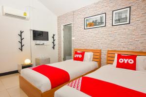 班康卡臣OYO Capital O 390 Nana River Kaeng Krachan的红色和白色的客房内的两张床
