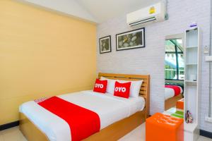班康卡臣OYO Capital O 390 Nana River Kaeng Krachan的一间卧室配有两张带红色枕头的床