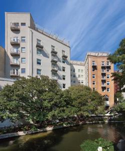 圣安东尼奥Club Wyndham Riverside Suites的两座高楼前的一条河流