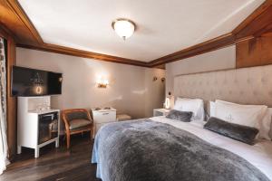 采尔马特Boutique Hotel Albana Real - Restaurants & Spa的酒店客房设有一张大床和一张书桌。