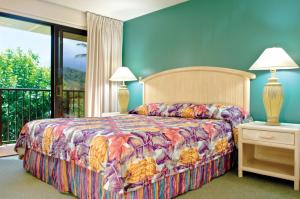利胡埃Kauai Beach Villas的一间卧室配有一张带彩色床罩的床