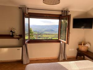 塞吉阿诺Vitabella Toscana的一间卧室设有美景大窗户