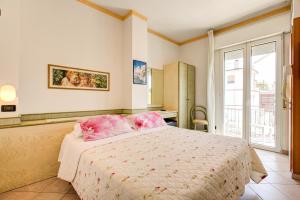 里米尼查尔斯公寓酒店的一间卧室配有一张带粉色床单的床和一扇窗户。