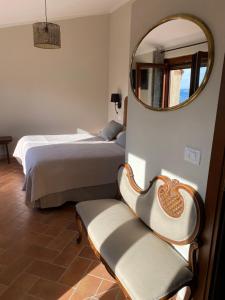 塞吉阿诺Vitabella Toscana的一间卧室配有两张床、镜子和椅子