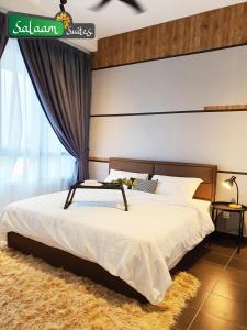 哥打巴鲁Troika Kota Bharu by Salaam Suites的一间卧室配有一张带白色床罩的大床