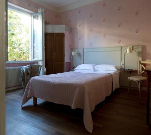 尼斯圣休伯特酒店的一间卧室配有一张带白色床罩的床和窗户。
